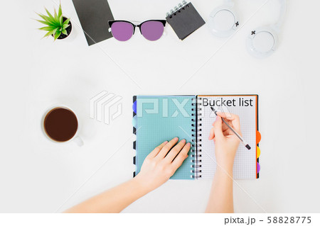 Flatlay with female hands writing bucket list. 58828775