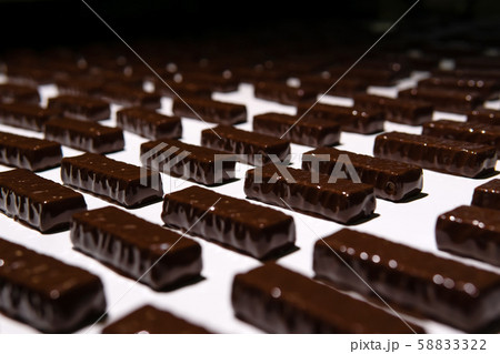 chocolate candies on the conveyor of a 58833322