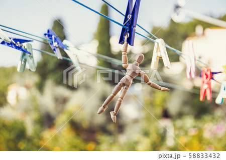 Wooden dummy puppet hanging with clothespin 58833432