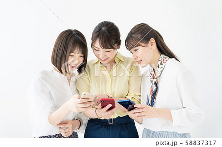 スマホを見せ合う女性グループ 58837317