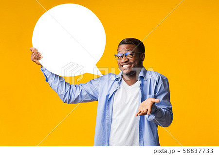 Funny Black Man Holding Speech Bubble Over Yellow Studio Background Funny Black Man Holding Speech Bubble Over Yellow Studio Background 58837733