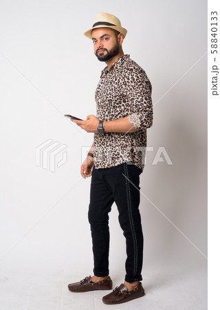 Full body shot of young bearded Indian man using phone 58840133