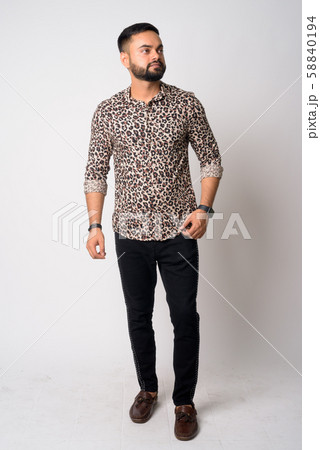 Full body shot of young bearded Indian man thinking Full body shot of young bearded Indian man thinking 58840194