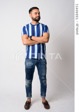Full body shot of young bearded Indian man thinking with arms crossed 58840451