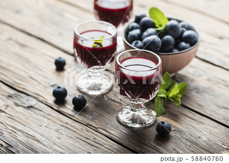 Sweet blueberry liqueur on the wooden table Sweet blueberry liqueur on the wooden table 58840760