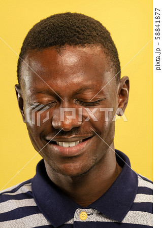 African-american young man's close up portrait on yellow background African-american young man's close up portrait on yellow background 58841877