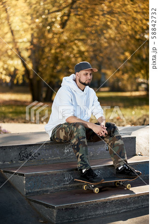 Man in skatepark with skateboard on warm autumn day Man in skatepark with skateboard on warm autumn day 58842732
