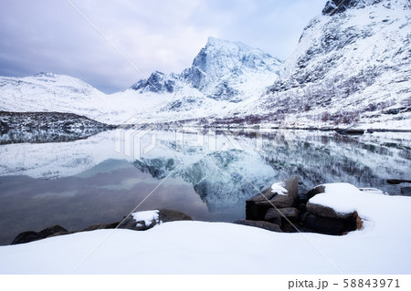 Mountain ridge and ice on the frozen lake surface. Natural landscape on the Lofoten islands, Norway. 58843971