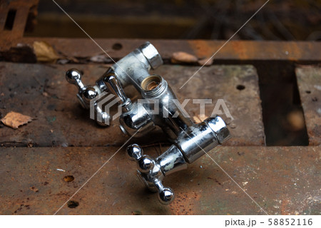Old water mixing crane on a rusty metal workbench. 58852116
