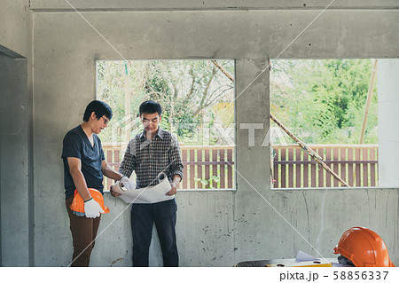 Engineer and architect discussing with foreman about project in building construction site 58856337