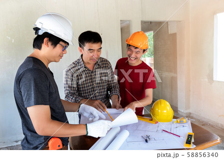 Engineer and architect discussing with foreman about project in building construction site 58856340