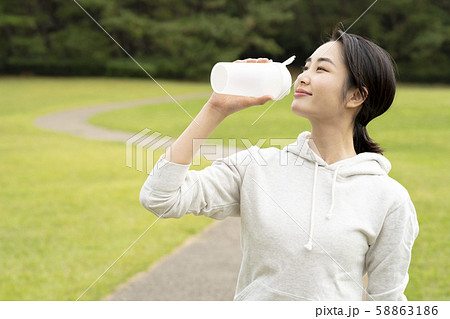 芝生の公園でプロテインを飲む女性 58863186