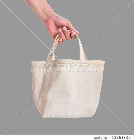 Tote bag canvas white cotton fabric cloth for eco shoulder shopping sack mockup blank template isolated on grey background (clipping path) with woman hand handling handle straps Tote bag canvas white cotton fabric cloth for eco shoulder shopping sack mockup blank template isolated on grey background (clipping path) with woman hand handling handle straps 58863330