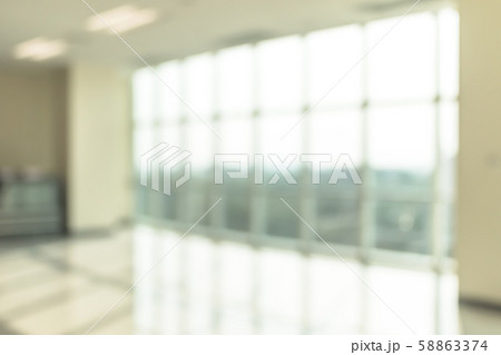 Blur background interior view looking out toward to empty office lobby and entrance doors and glass curtain wall 58863374