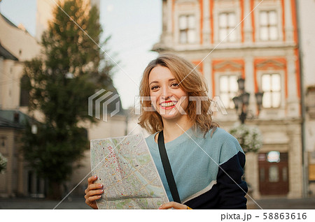 Young beautiful girl with blonde hair and blue casual clothes is standing on the square of ancient Young beautiful girl with blonde hair and blue casual clothes is standing on the square of ancient 58863616