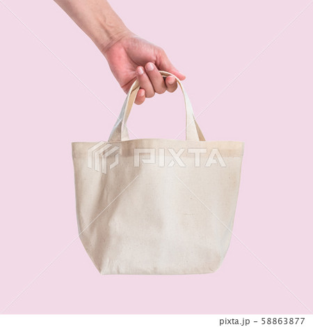 Tote bag canvas white cotton fabric cloth for eco shoulder shopping sack mockup blank template isolated on pink background (clipping path) with woman hand handling handle straps 58863877