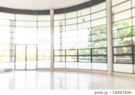 Blur background interior view looking out toward to empty office lobby and entrance doors and glass curtain wall Blur background interior view looking out toward to empty office lobby and entrance doors and glass curtain wall 58863896