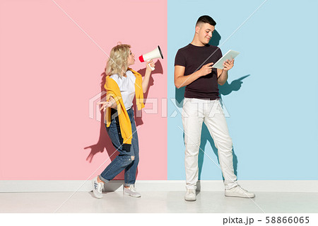 Young emotional man and woman on pink and blue background 58866065