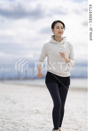 砂浜でランニングするのが日課の女性の写真素材