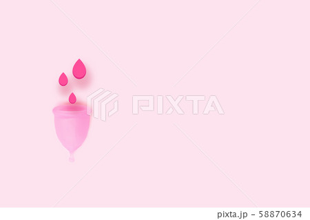 Pink menstrual cup with blood on pink background. 58870634