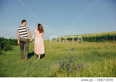 Beautiful couple spend time on a summer field Beautiful couple spend time on a summer field 58871640
