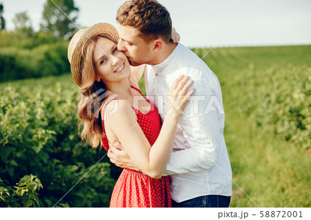 Beautiful couple spend time on a summer field Beautiful couple spend time on a summer field 58872001