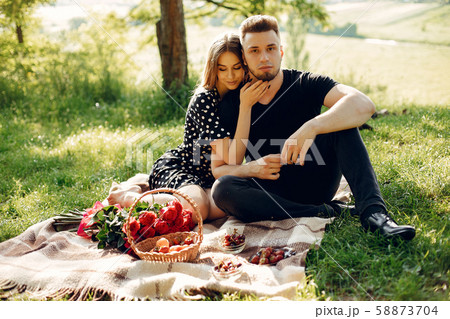 Beautiful couple spend time in a summer field Beautiful couple spend time in a summer field 58873704