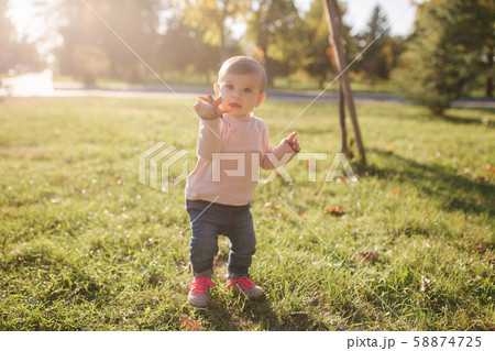 Adorable little girl walking in the parl in autumn weather. Happy baby girl Adorable little girl walking in the parl in autumn weather. Happy baby girl 58874725