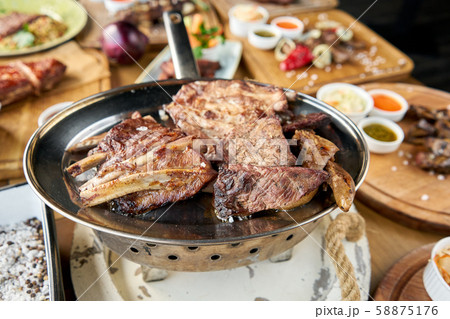 Various grilled meat set heated on coals. Barbecue restaurant menu. Many different food on the table 58875176