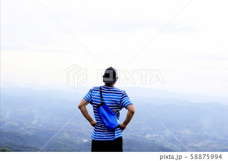 A man standing on cliff and see over view in nature. Tourist show  hands up and enjoying fresh air. A man enjoying free happiness in beautiful Thailand landscape. 58875994