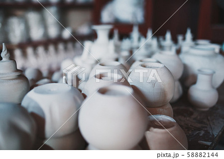 Making ceramic pots and cups from white clay 58882144