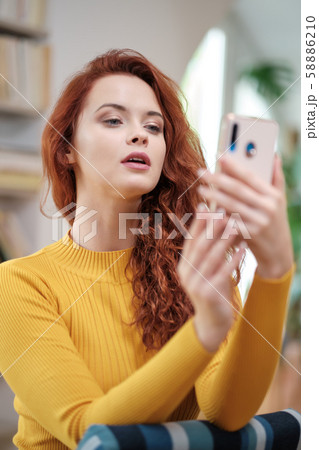 Woman taking a selfie with a smoothie using a Woman taking a selfie with a smoothie using a 58886210