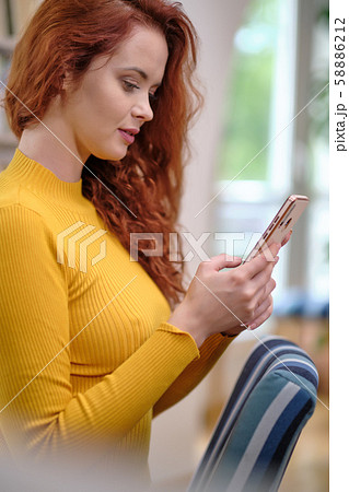 Woman taking a selfie with a smoothie using a Woman taking a selfie with a smoothie using a 58886212