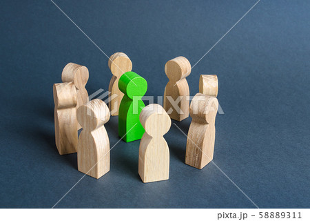 A green human figure is surrounded by a circle of people. Cooperation and collaboration. Fundraising and people around the idea. To unite like-minded persons. Leader and leadership skills. 58889311