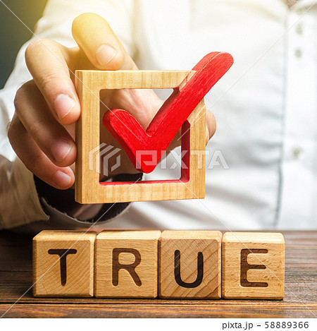 A man holds a red check mark over word True. Confirm the veracity and truth. Fight against fake news hostile propaganda. Confirmation facts, refutation of rumors. Debunking Myths and Misconceptions 58889366