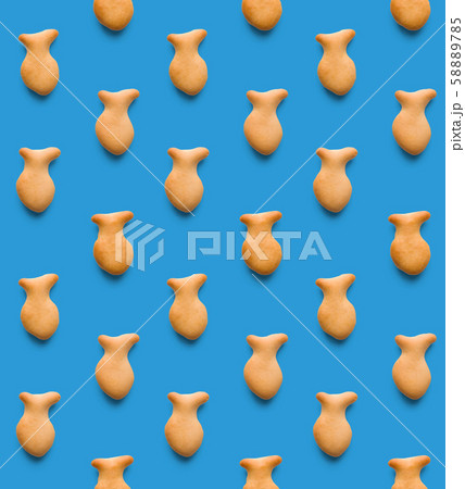 Rounded fresh crispy fish shaped cookies on light blue background. Seamless texture. Top view Rounded fresh crispy fish shaped cookies on light blue background. Seamless texture. Top view 58889785