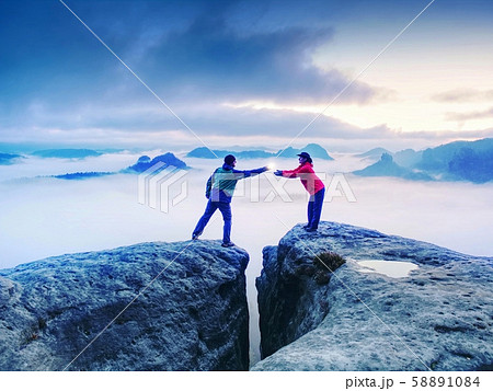 Couple hold light  high above danger gulch between Couple hold light  high above danger gulch between 58891084