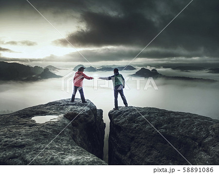 Girl is putting lightning lantern over rocky edge 58891086