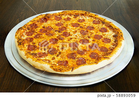 Fresh pepperoni pizza on woooden table in restaurant. Fresh pepperoni pizza on woooden table in restaurant. 58893059