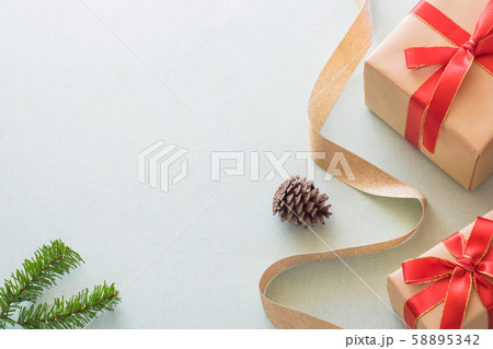 Christmas background with gift boxes, pine cone and decorations on light blue background. Preparation for holidays. Top view with copy space. 58895342