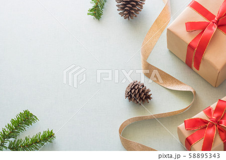 Christmas background with gift boxes, pine cone and decorations on light blue background. Preparation for holidays. Top view with copy space. Christmas background with gift boxes, pine cone and decorations on light blue background. Preparation for holidays. Top view with copy space. 58895343
