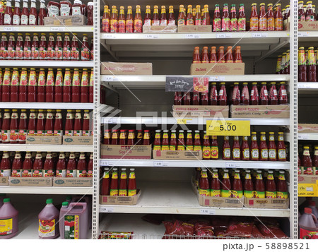 Selective focused variety of cooking sauce in the bottles displayed for sale in the supermarkets. Displayed on racks and separated by the brand to facilitate buyers. 58898521