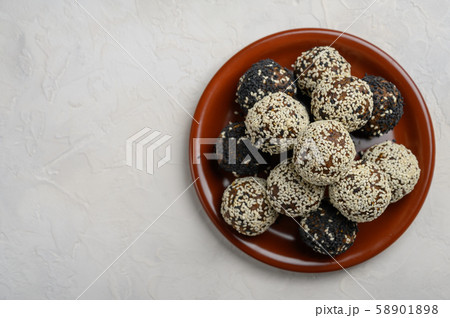 Homemade energy balls on a brown ceramic plate on a white background 58901898