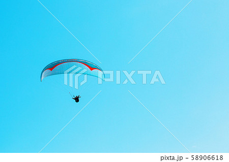 Paraglider soars against the blue sky with clear 58906618