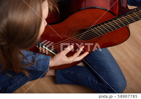 woman play guitar at home 58907785