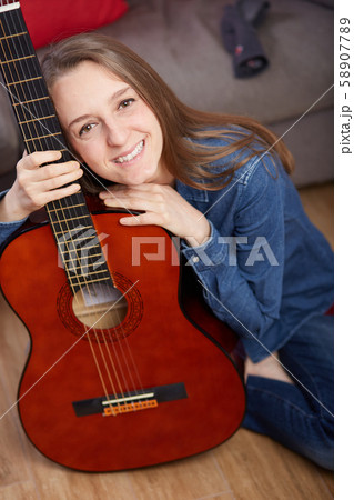 woman play guitar at home 58907789