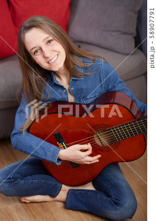 woman play guitar at home 58907791