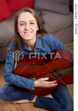 woman play guitar at home 58907793