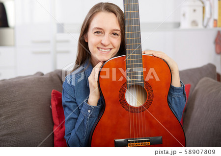 woman play guitar at home woman play guitar at home 58907809