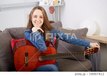 woman play guitar at home woman play guitar at home 58907812